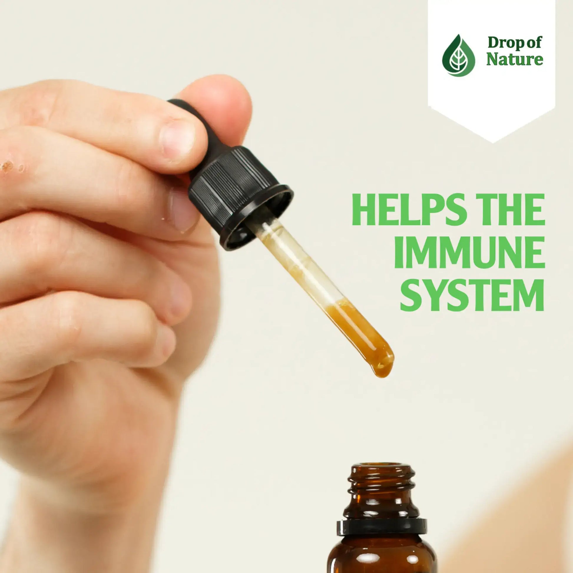 A hand holding a dropper above a brown glass bottle, with the label highlighting immune system support.
